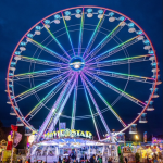 Das bunt beleuchtete RiesenradMovie Star in der Kullisse des Augsburger Plärrers bei Nacht