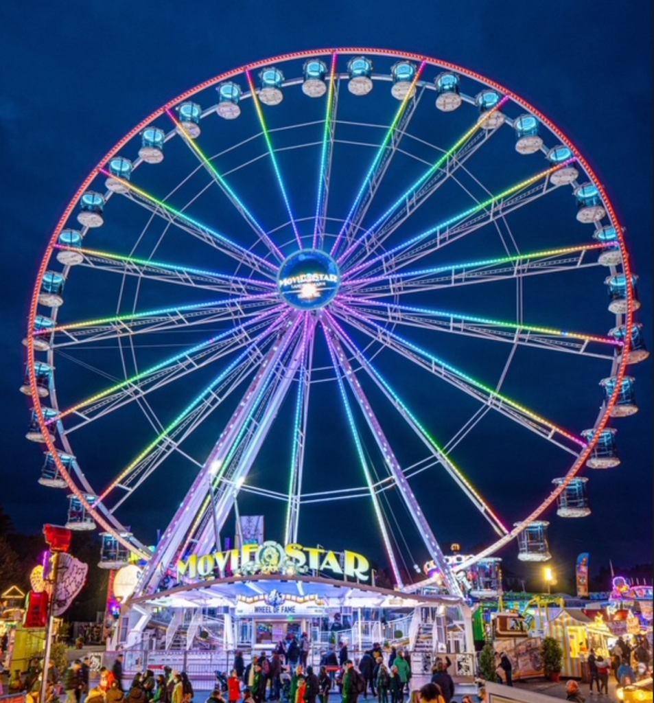 Das bunt beleuchtete RiesenradMovie Star in der Kullisse des Augsburger Plärrers bei Nacht